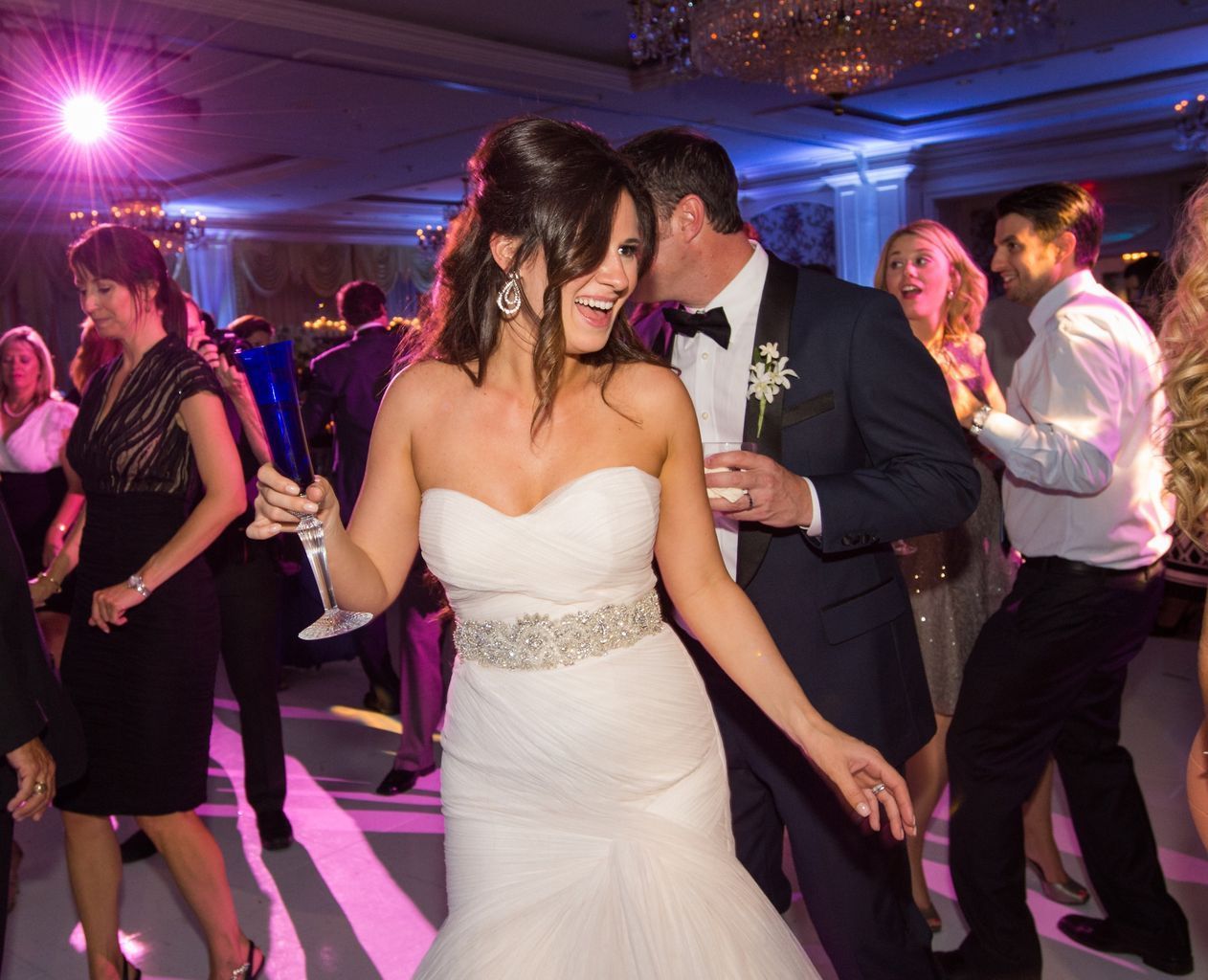 A bride and groom are dancing at their wedding reception