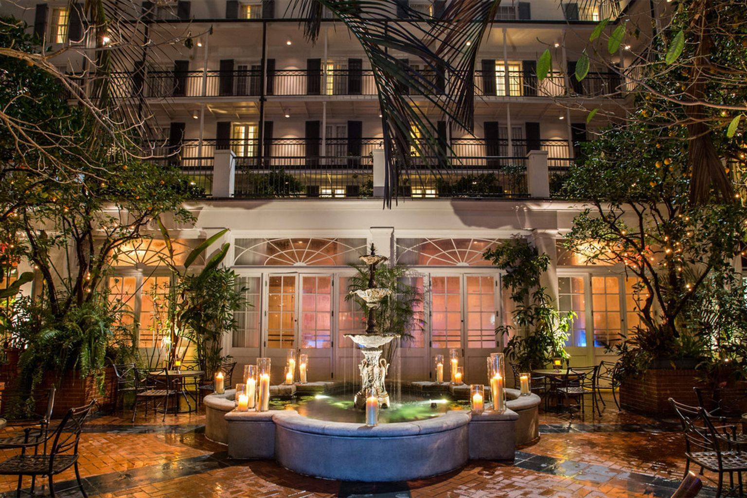 There is a fountain in the middle of the courtyard of a hotel.