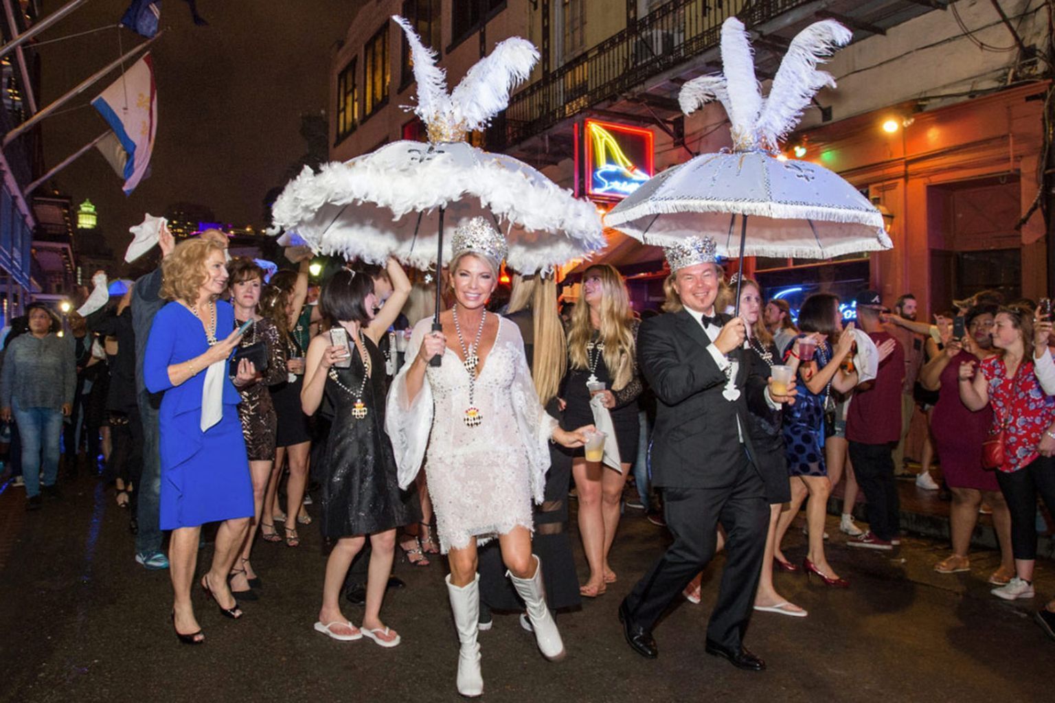 A group of people are walking down a street with umbrellas on their heads.