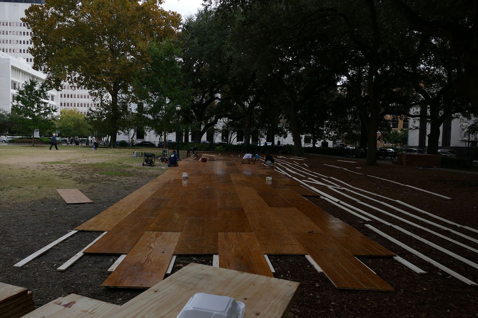 A large wooden floor is being built in a park