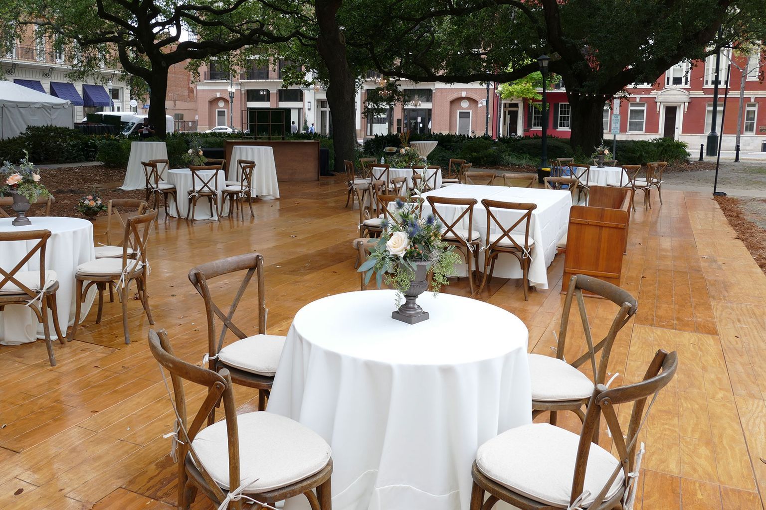 A wooden floor with tables and chairs set up for a party
