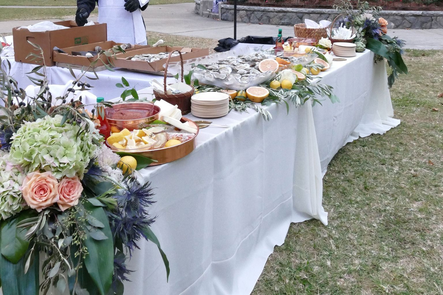 A long table with lots of food and flowers on it.