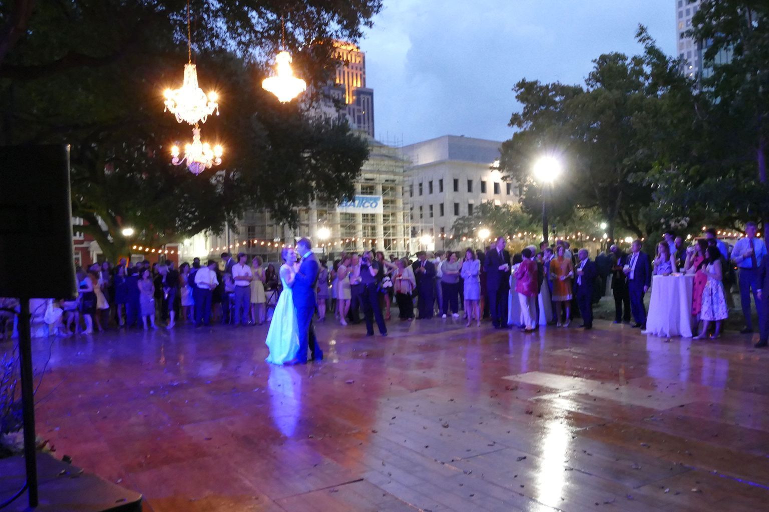 A group of people are dancing on a dance floor in a park.