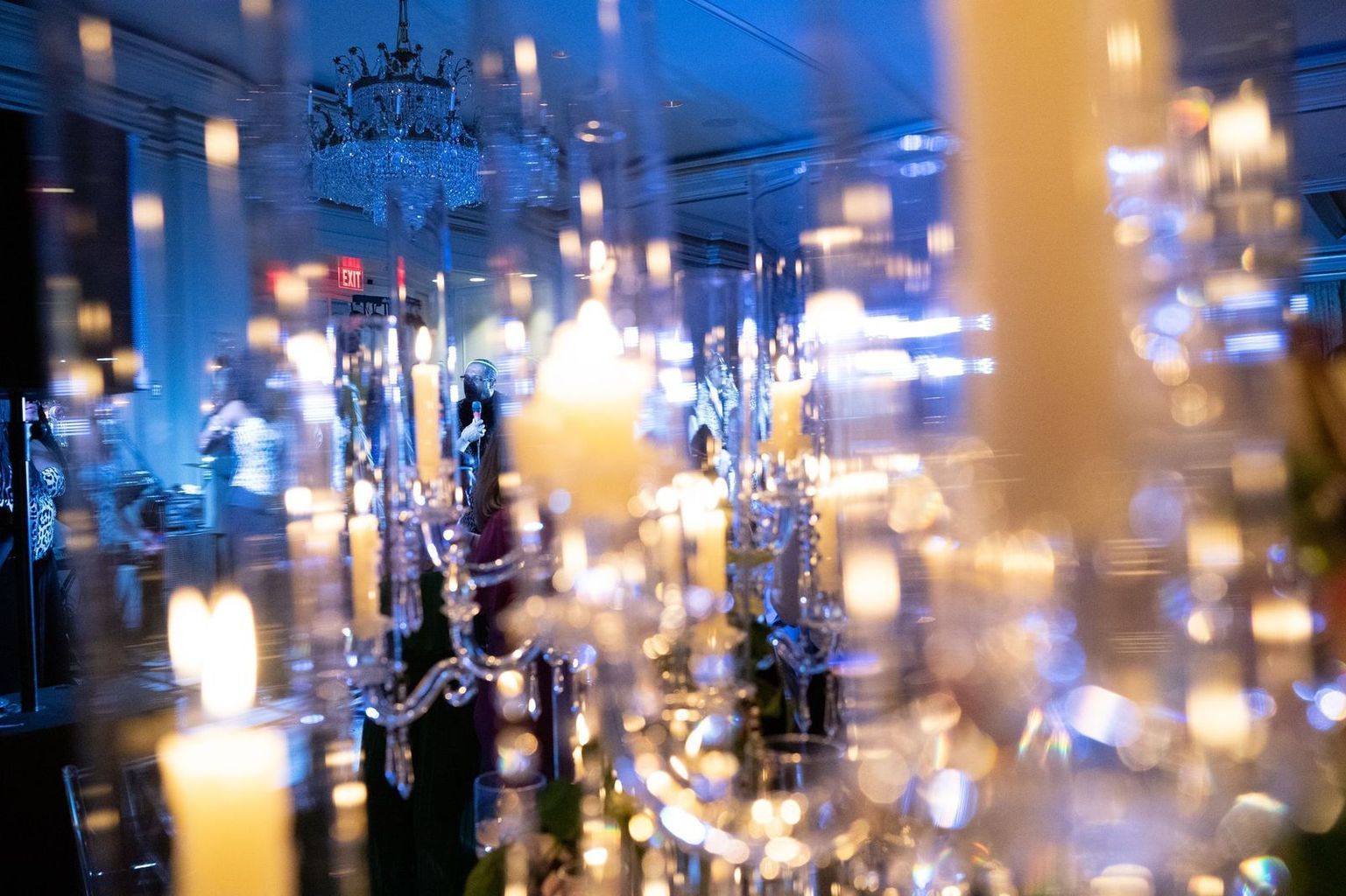 A blurry picture of a room filled with candles and chandeliers.