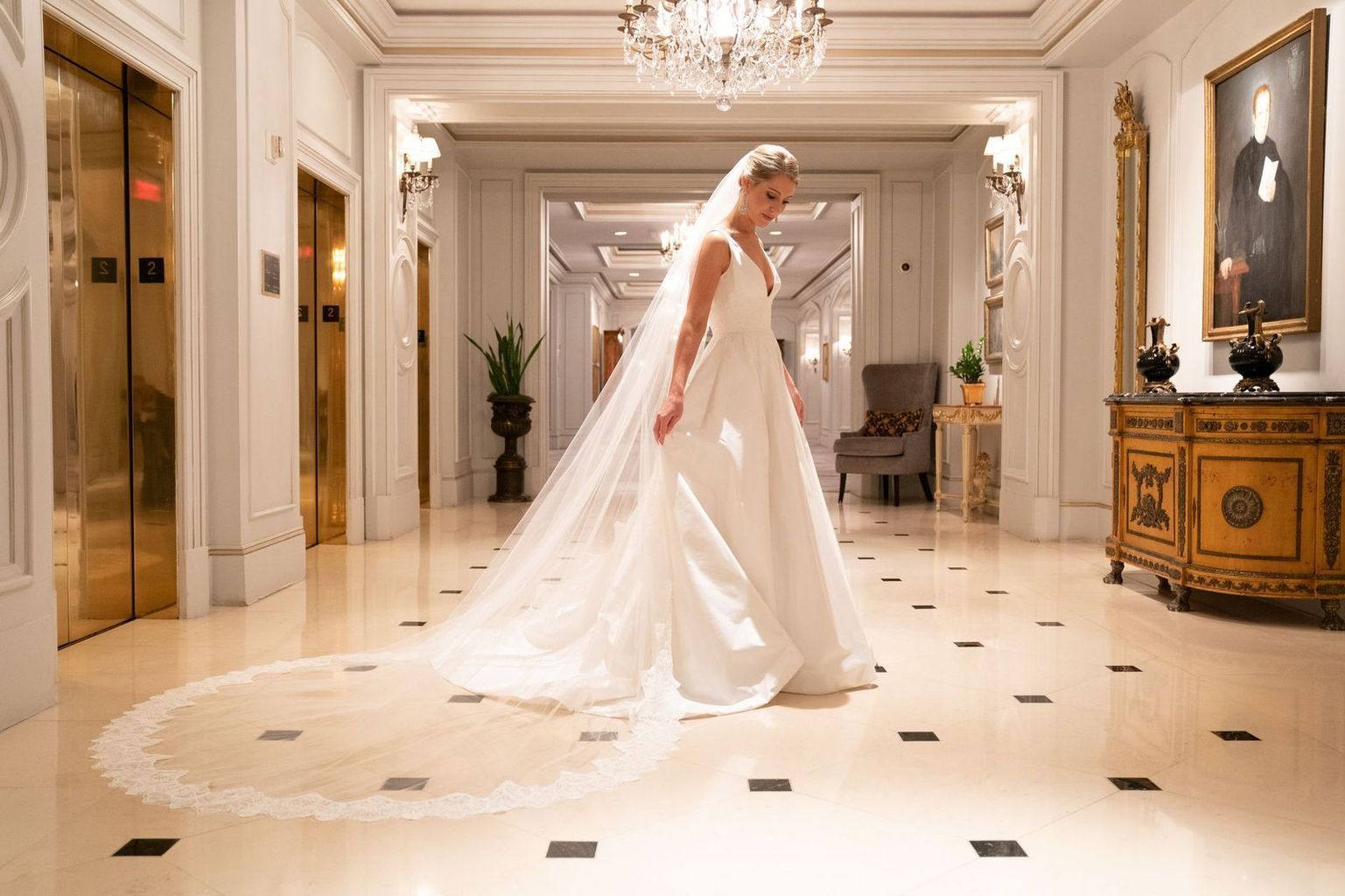 A large room filled with tables and chairs and a chandelier.