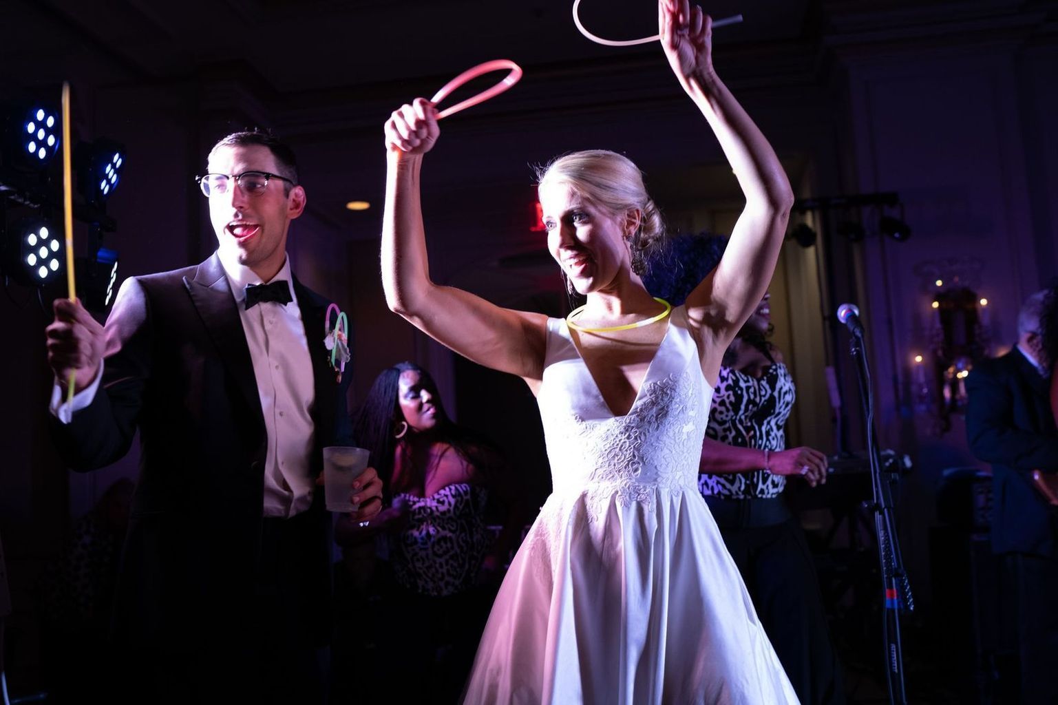 A bride and groom are dancing with hula hoops at their wedding reception.