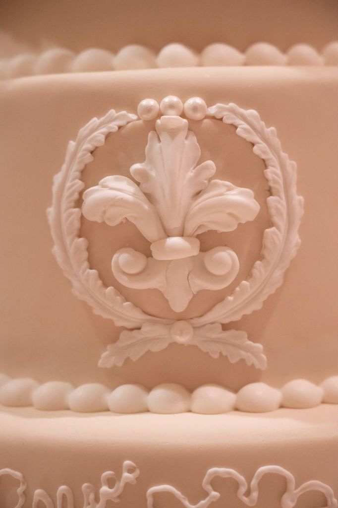 A close up of a cake with a fleur de lis on it.