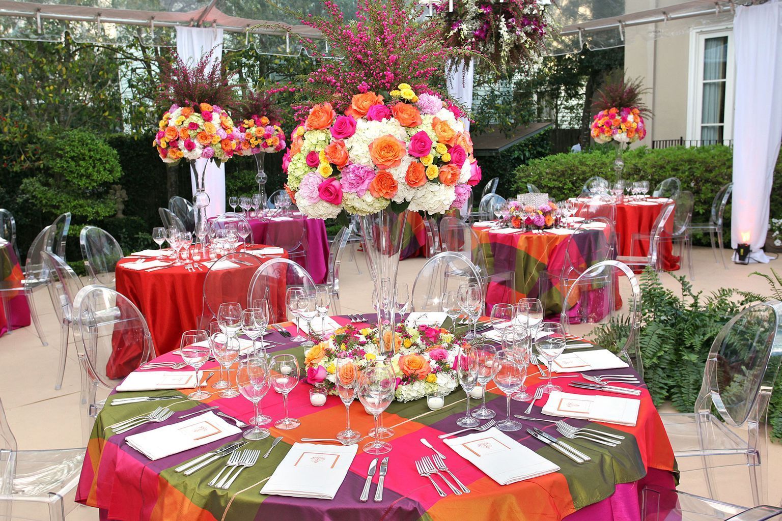 A table set for a party with a vase of flowers on it.