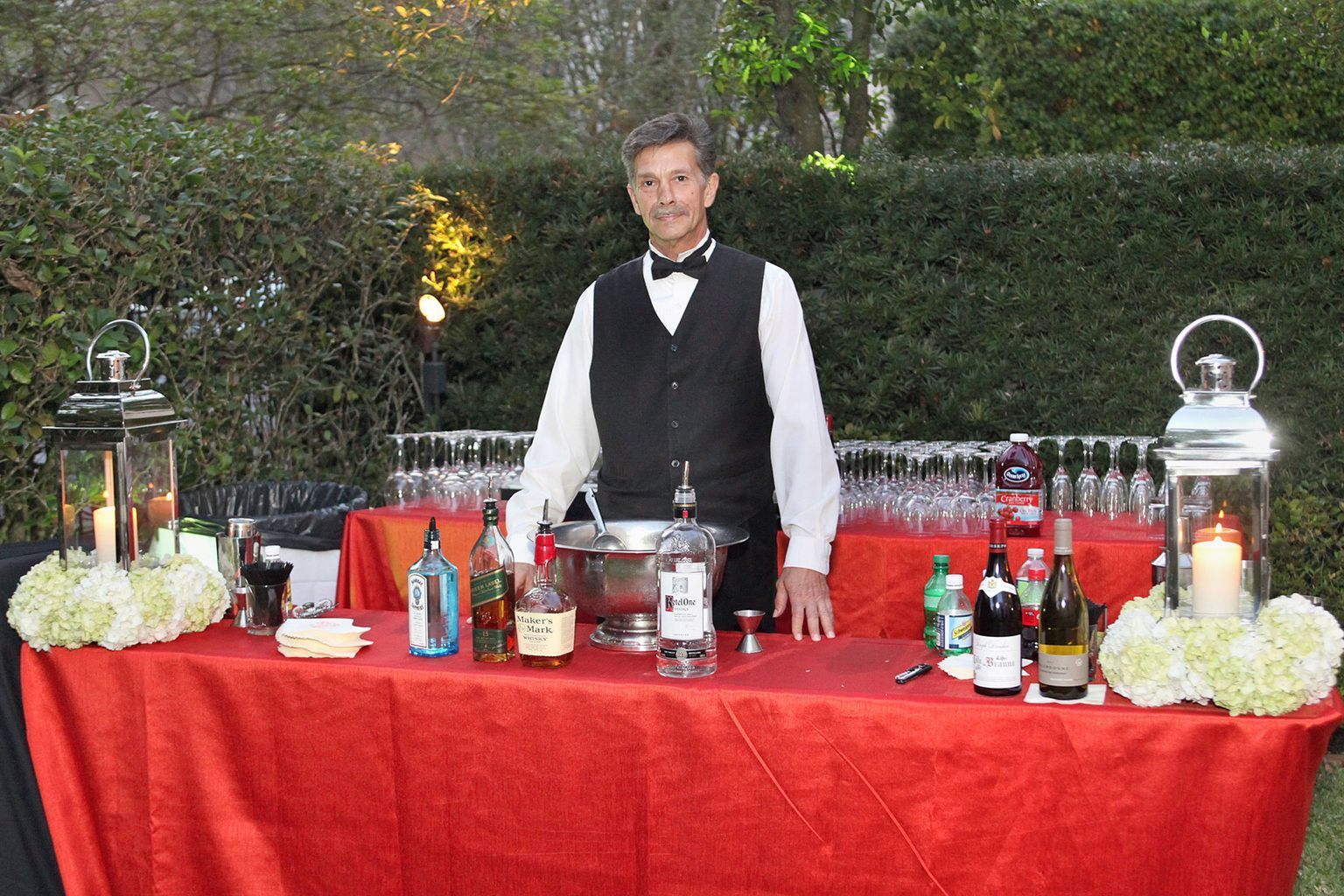 A man in a tuxedo is standing in front of a bar.