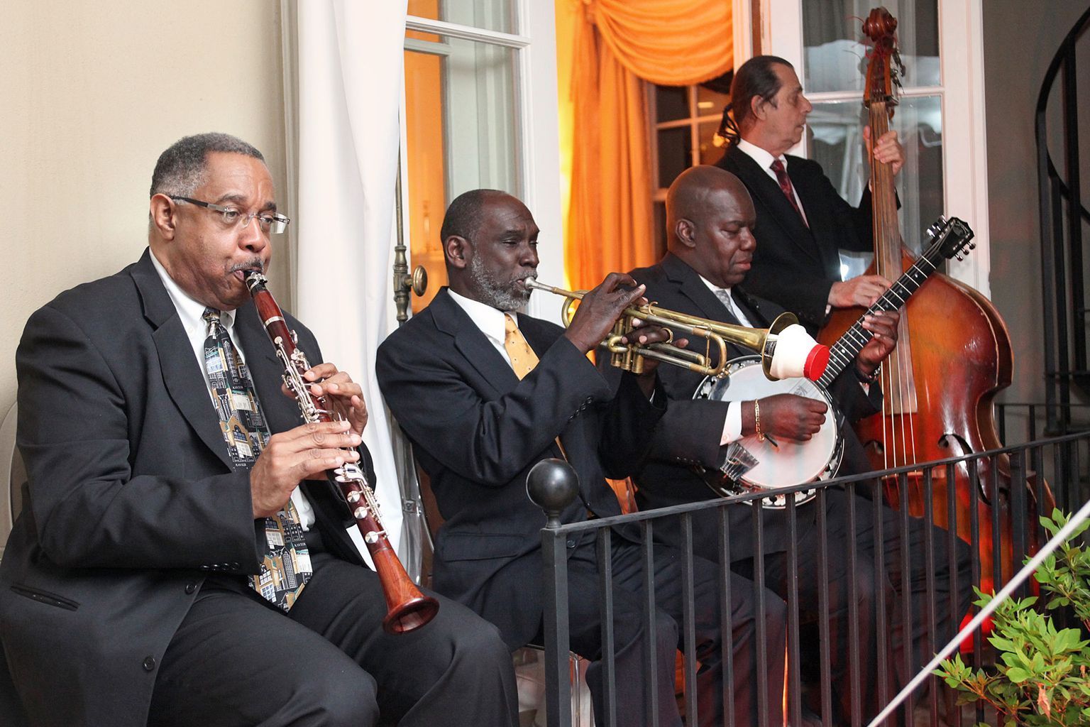 A group of men are playing musical instruments on a balcony.