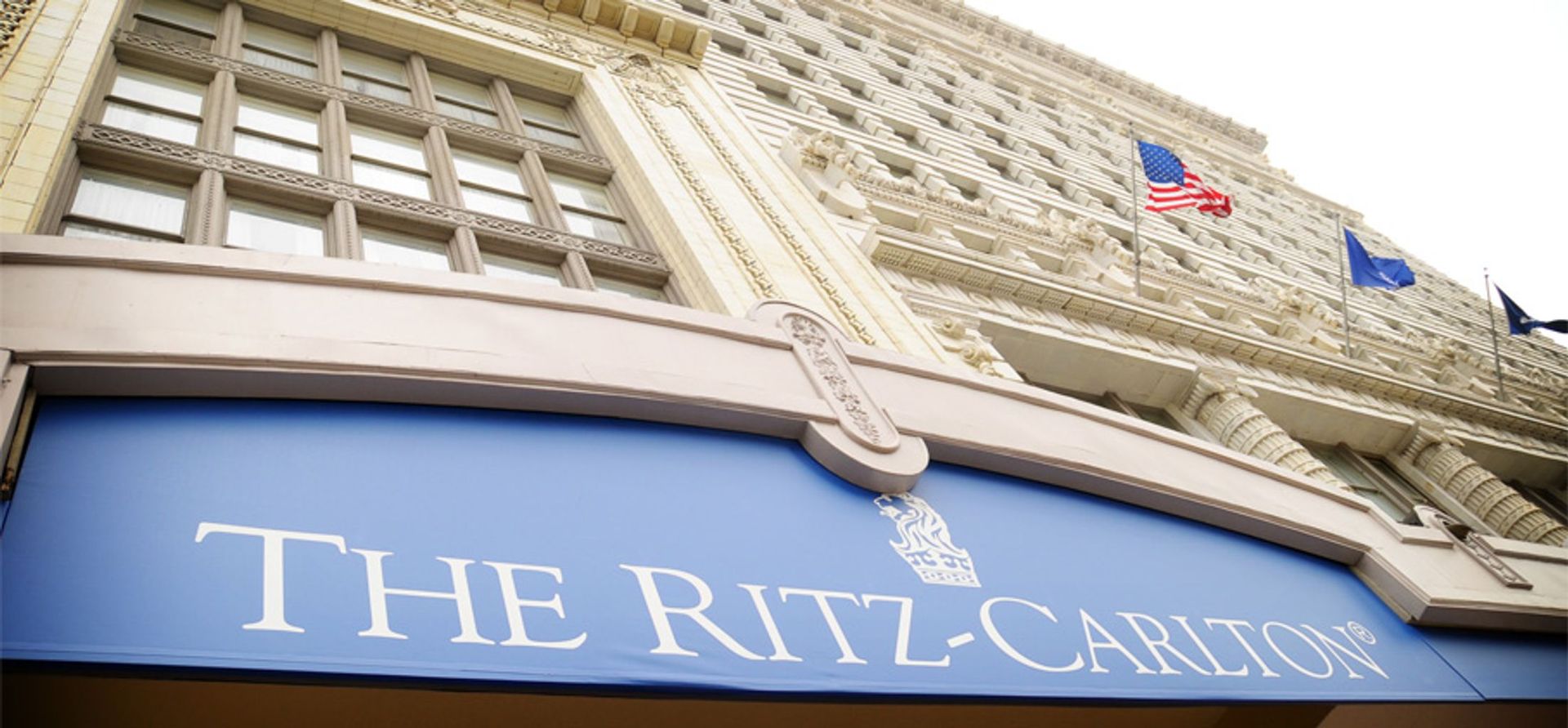 A building with a blue awning that says the ritz carlton