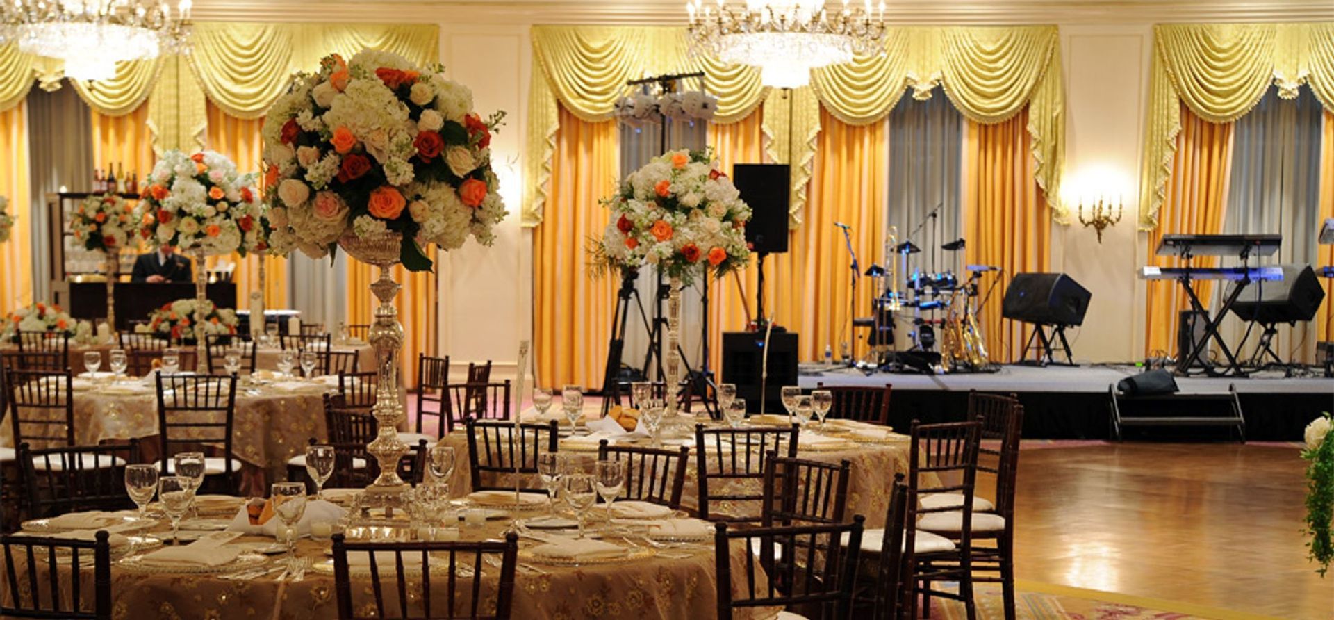 A large room with tables and chairs set up for a wedding reception.