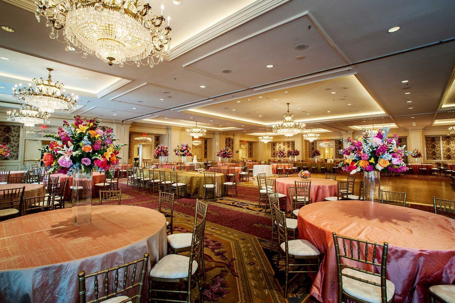 A large room with tables and chairs set up for a wedding reception.