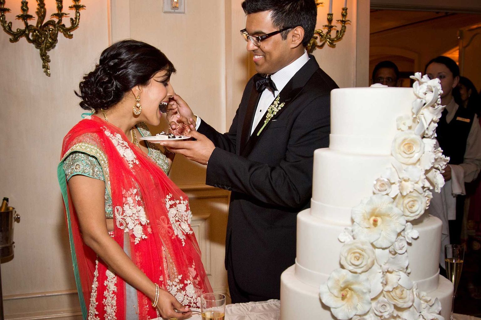 A bride and groom are cutting their wedding cake together