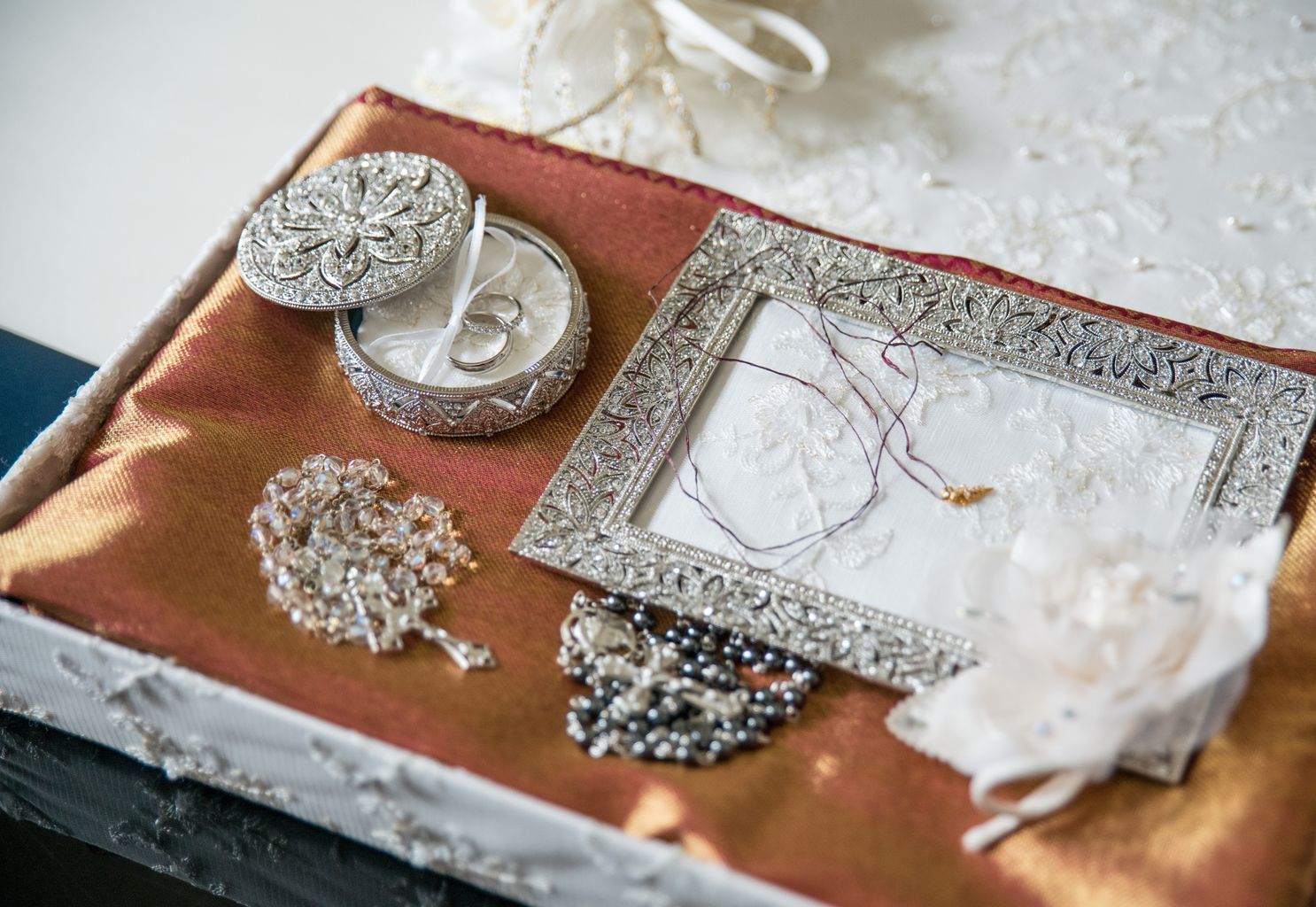 A box filled with jewelry and a picture frame on a table.