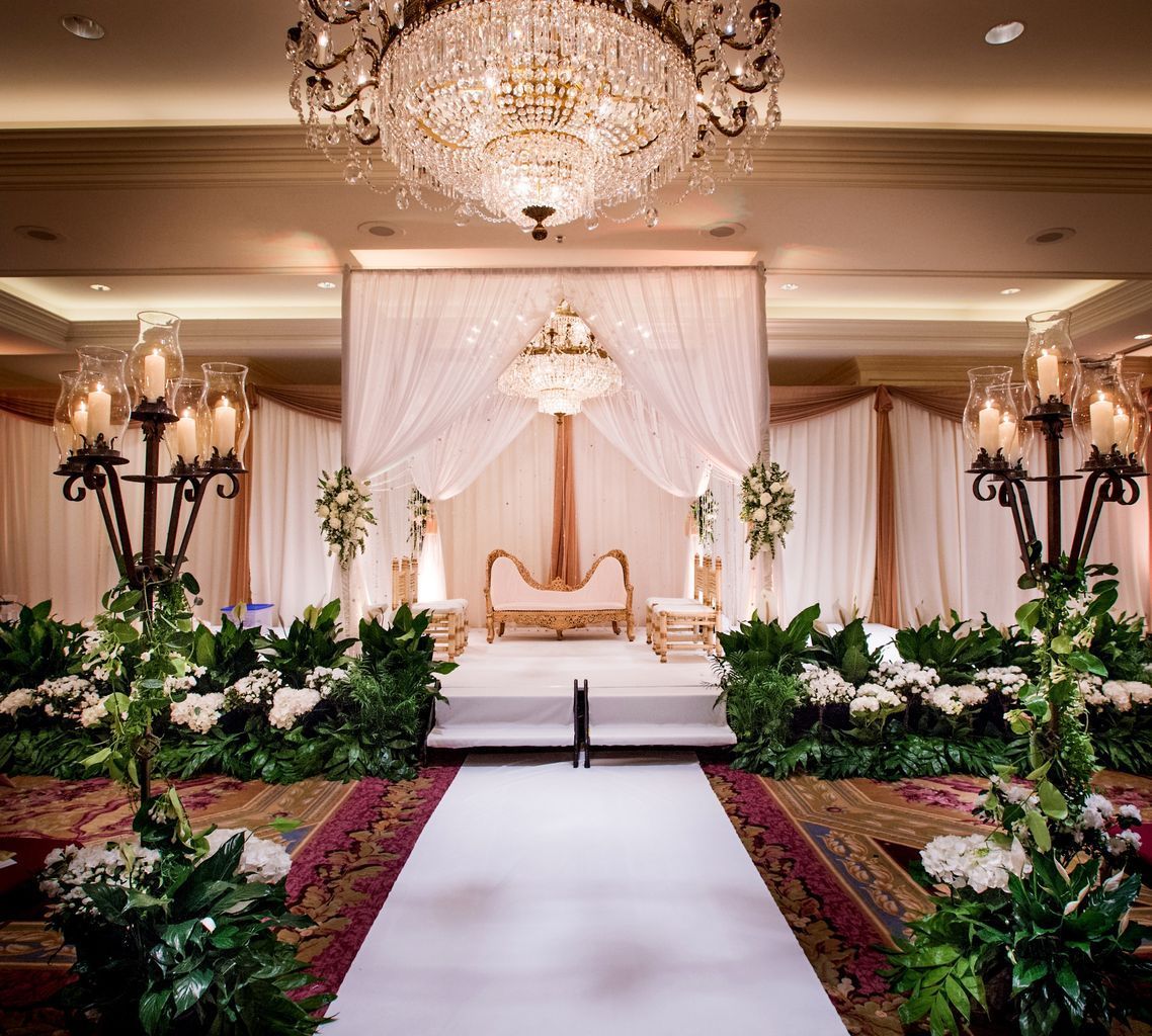 A large room decorated for a wedding with a chandelier hanging from the ceiling