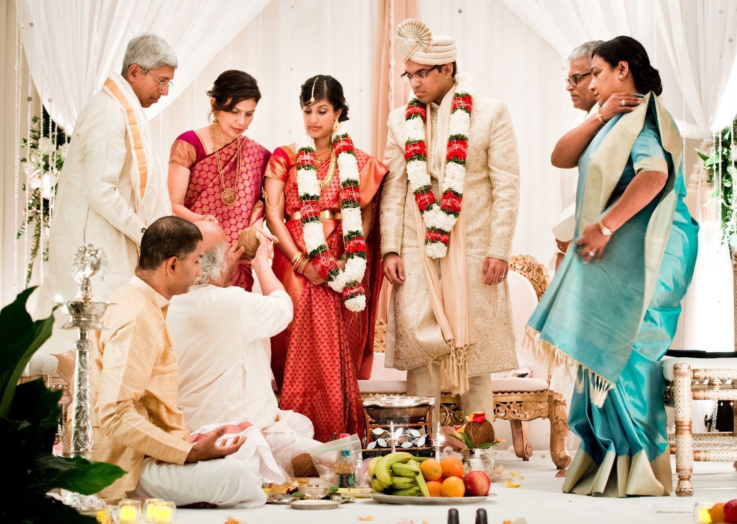A group of people are standing around a bride and groom at a wedding ceremony.