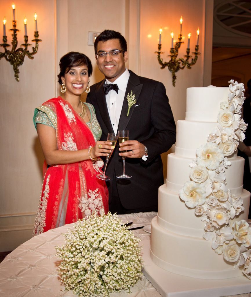 A man and a woman standing in front of a wedding cake
