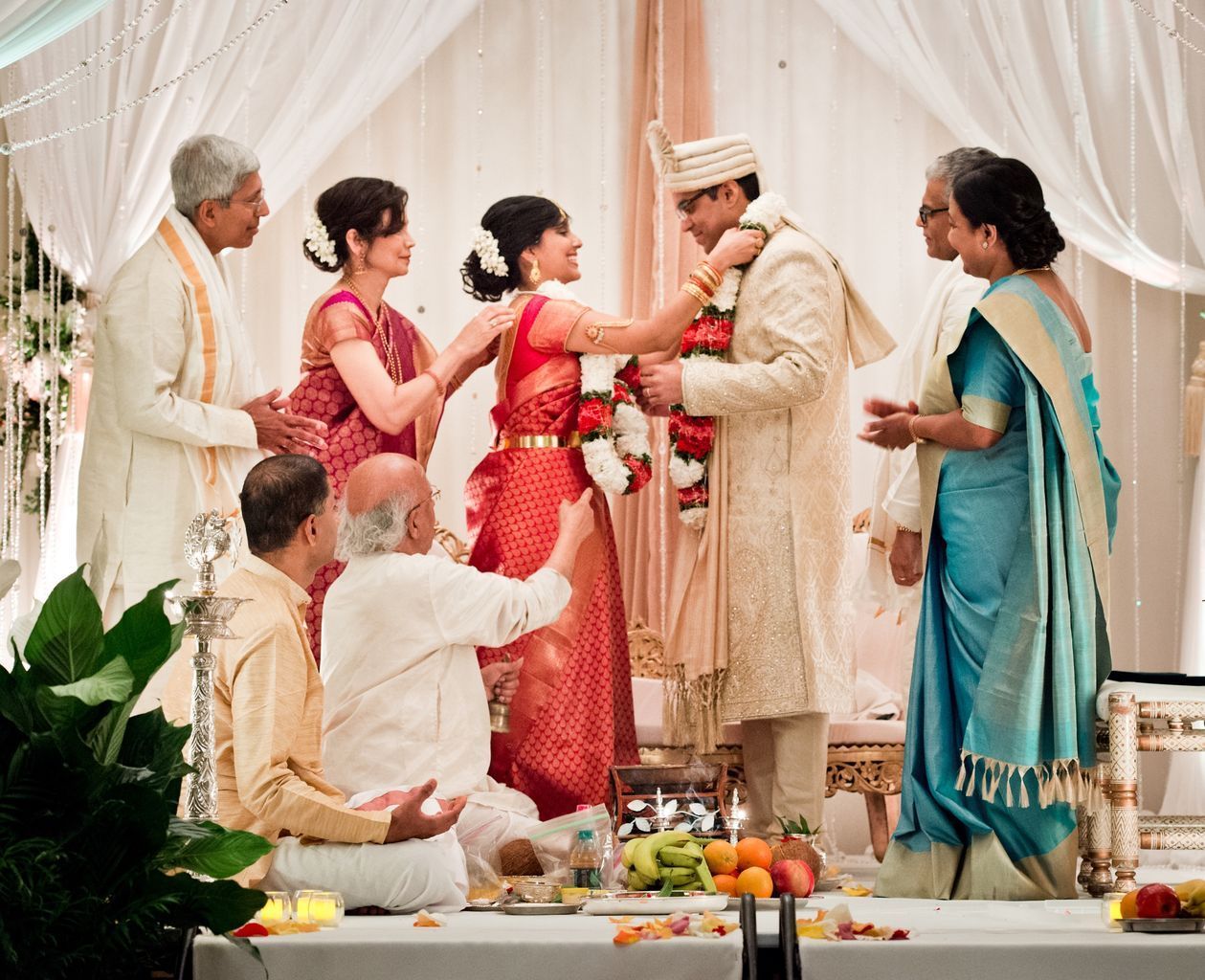A group of people are standing around a bride and groom at a wedding ceremony.