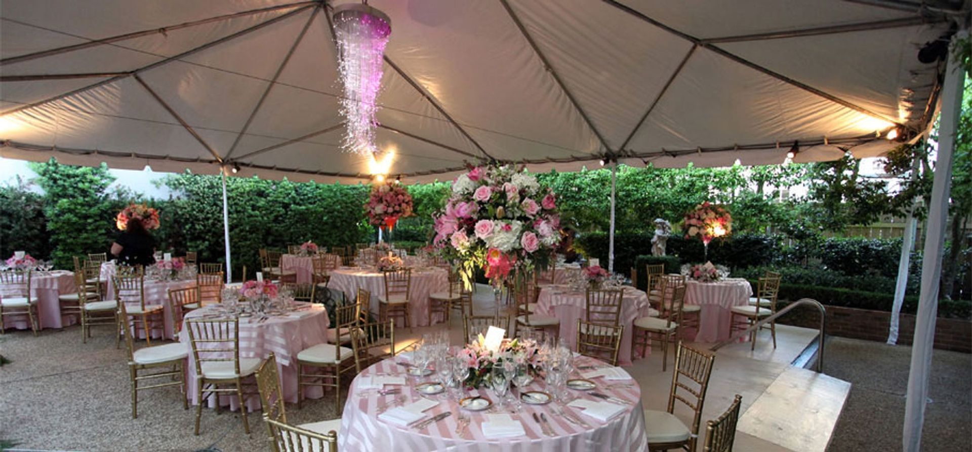 Tables and chairs are set up under a tent for a wedding reception.