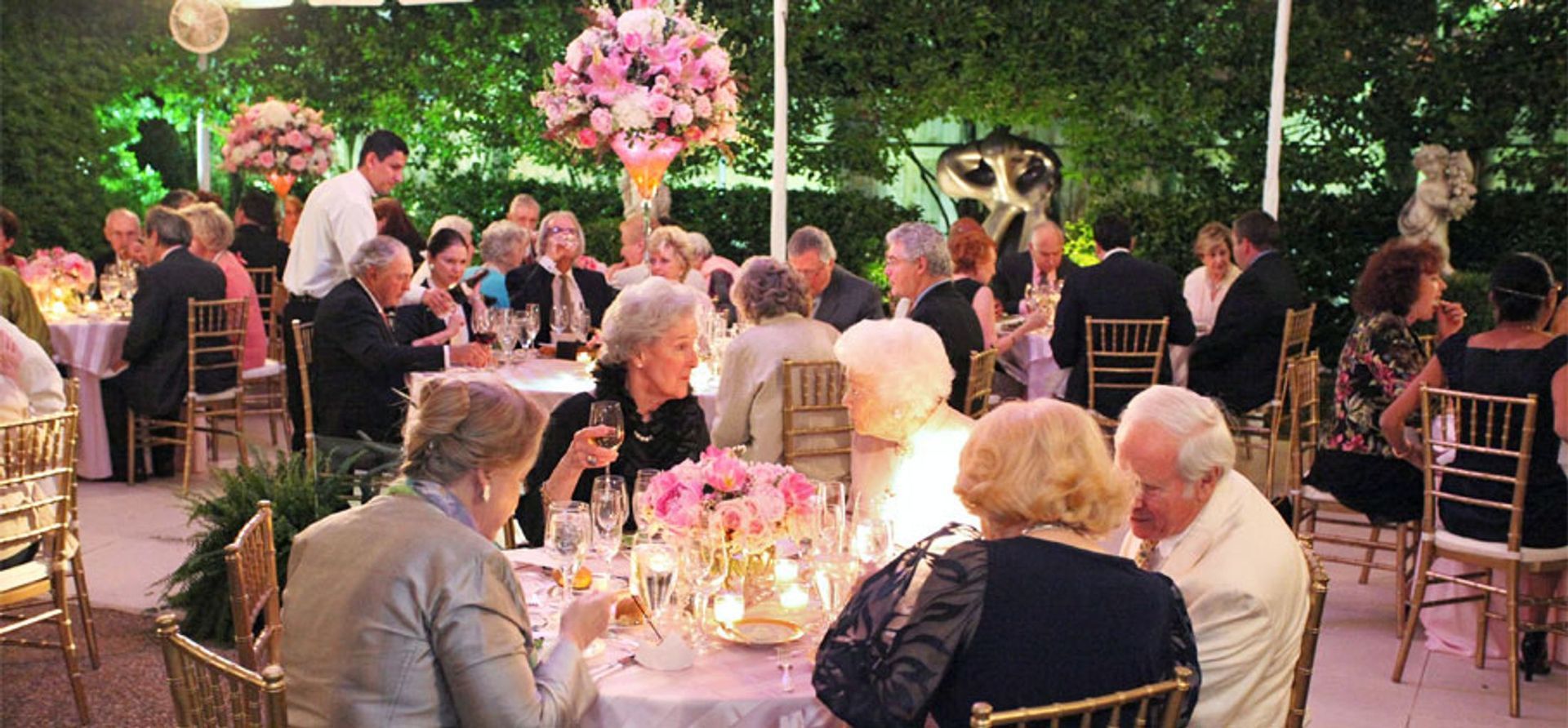 A large group of people are sitting at tables at a wedding reception.