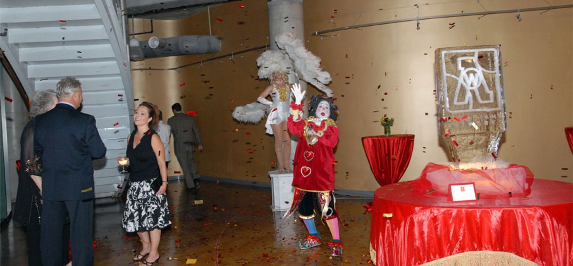 A group of people standing in a hallway with a clown in the background