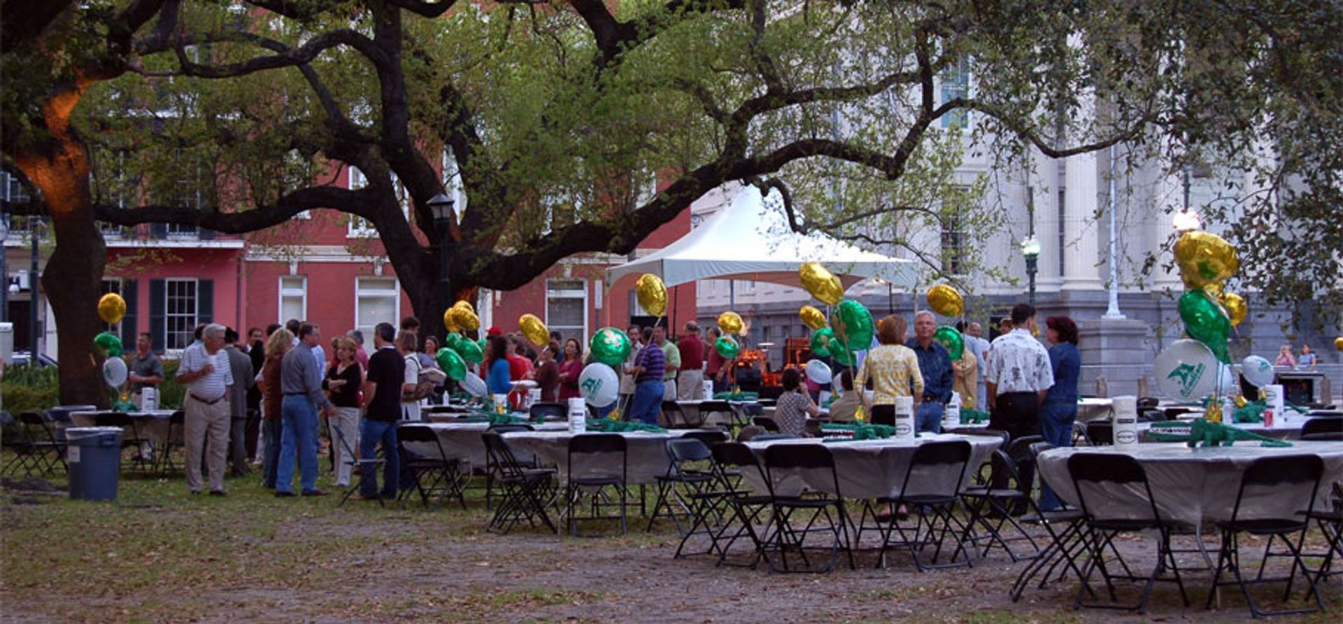 A group of people standing around tables with balloons on them