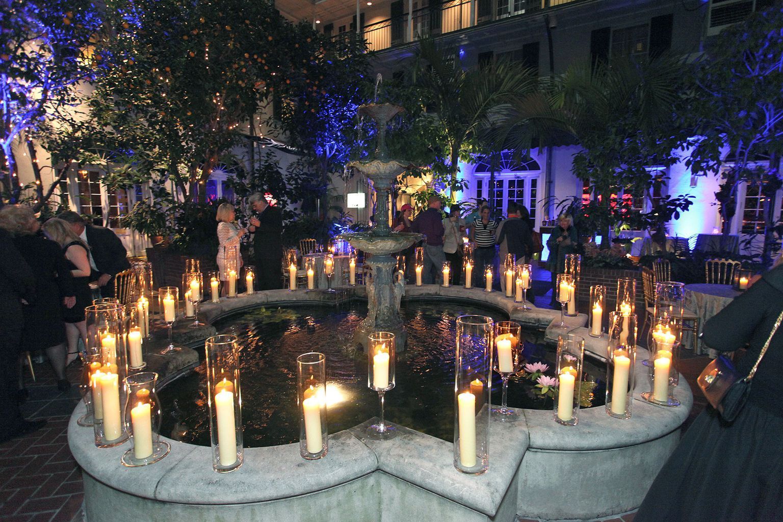 A fountain filled with candles is lit up at night