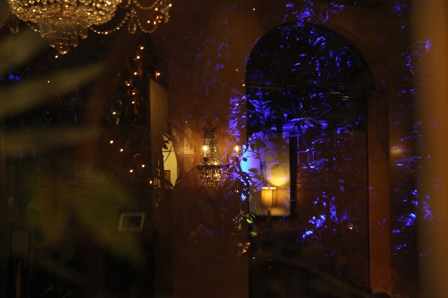 A room with a chandelier and purple lights on the wall.