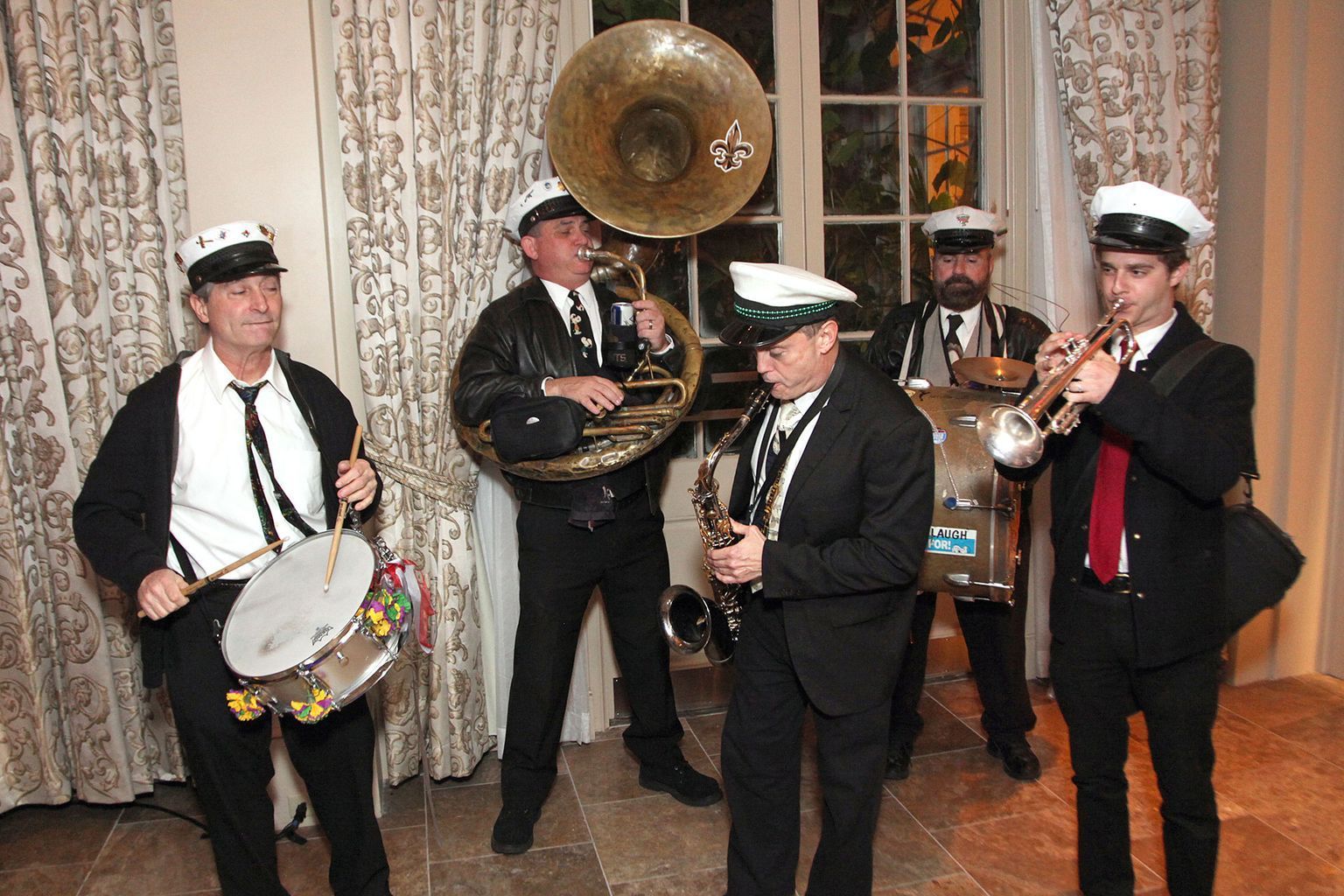 A group of men in suits and hats are playing instruments.