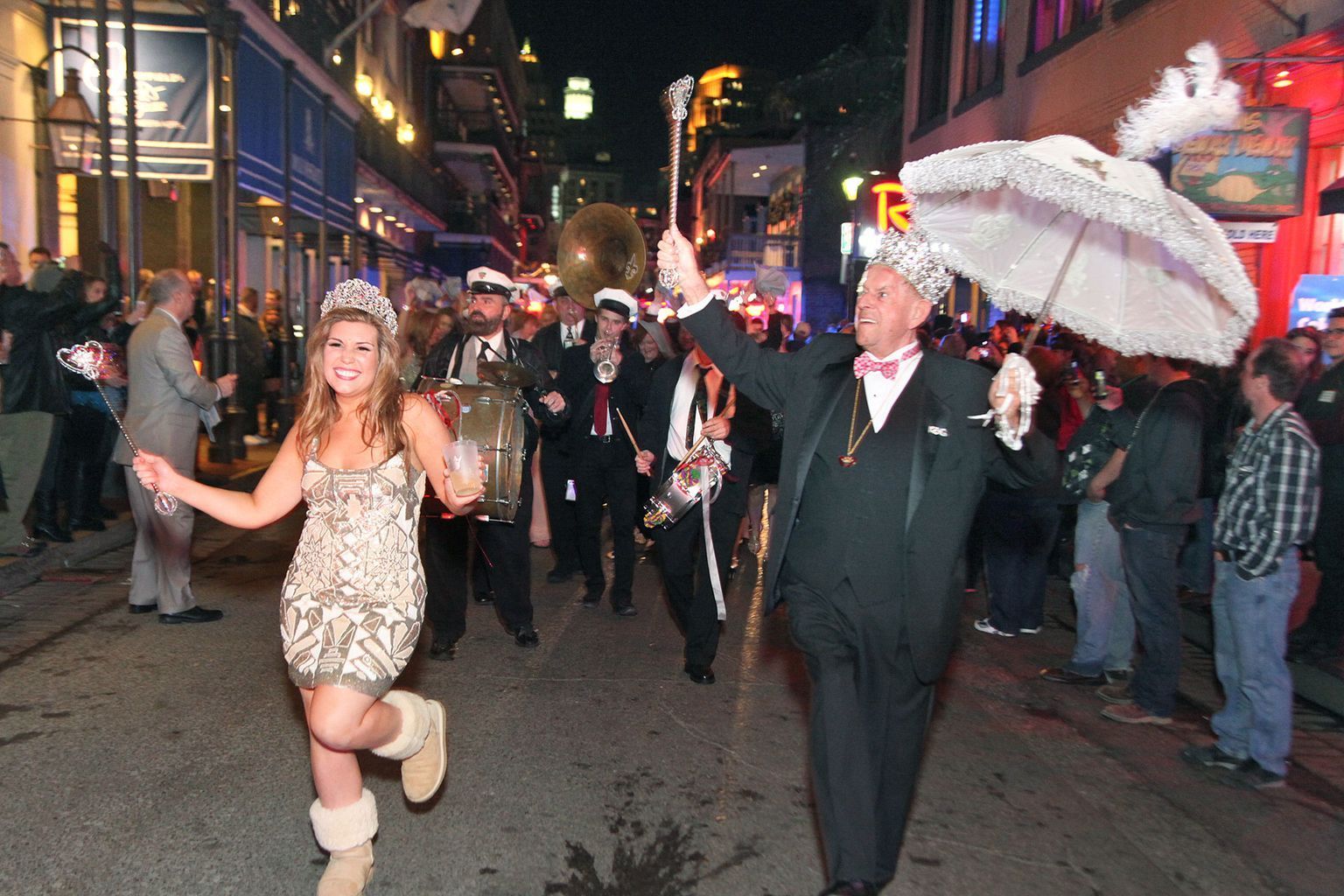 A man and a woman are walking down a street holding umbrellas.