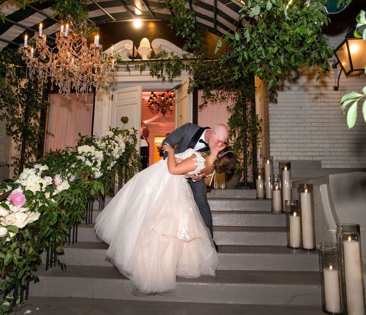 A bride and groom are kissing on a set of stairs.