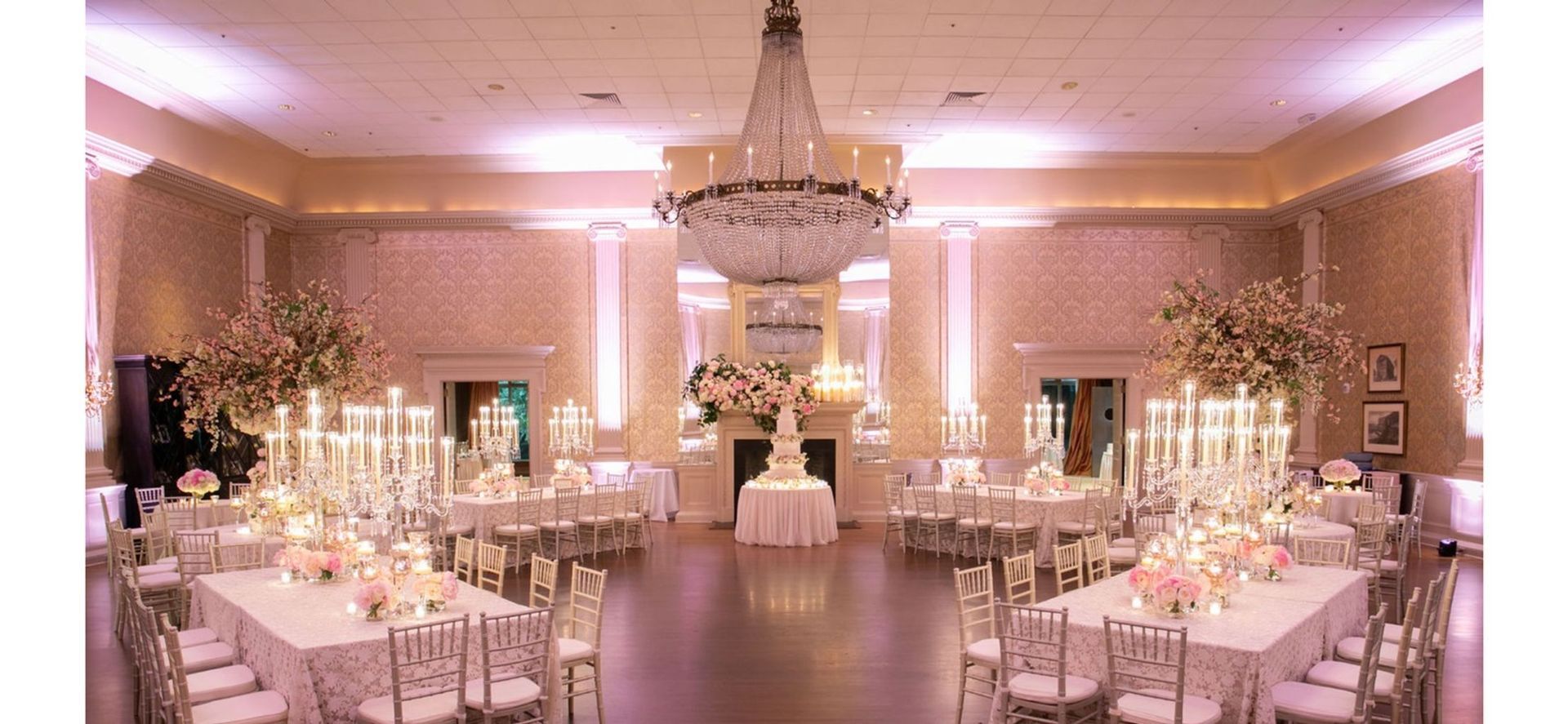 A large room filled with tables and chairs and a chandelier.