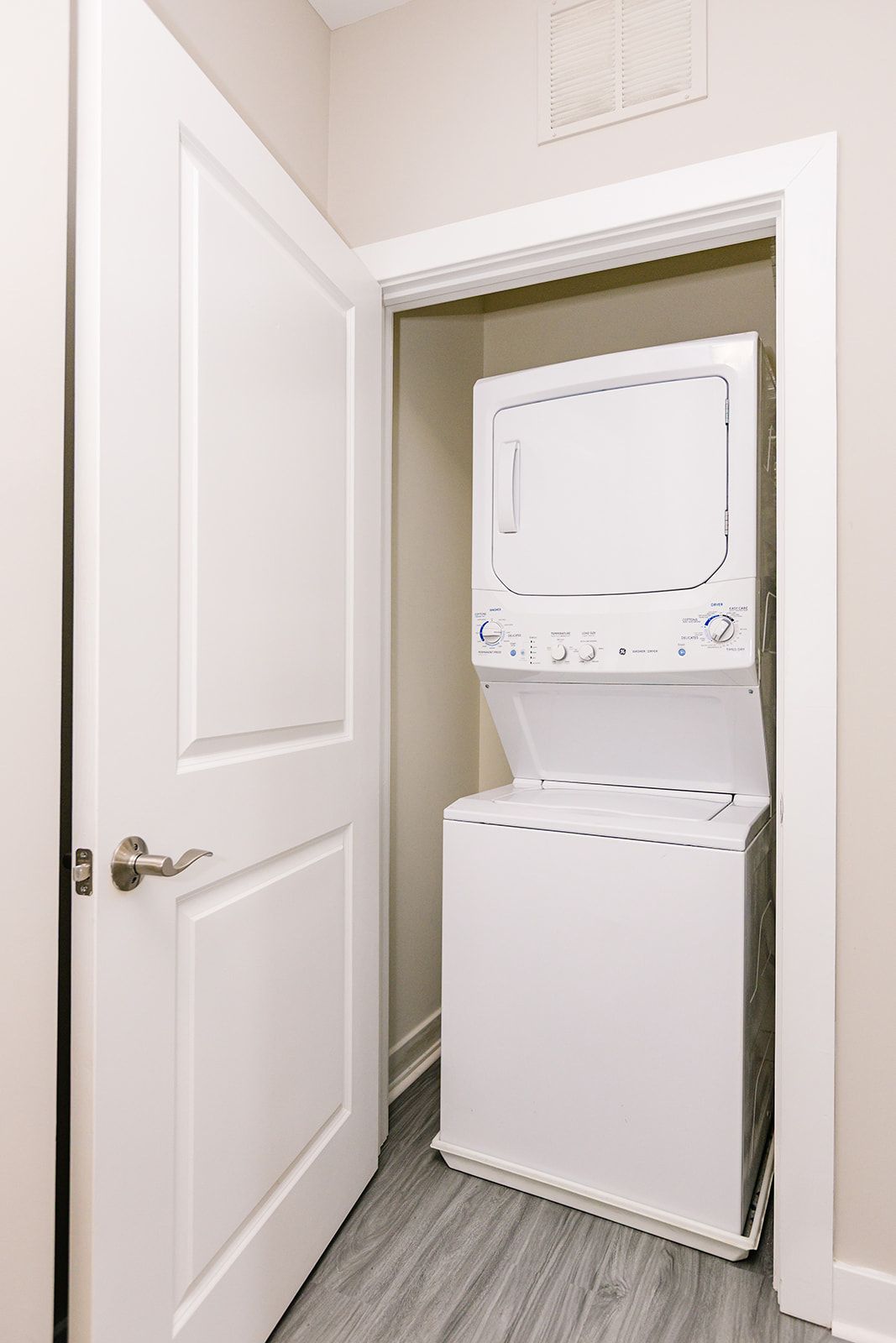 Bedroom with two twin beds, orange blankets, white walls, and a large window with blinds.