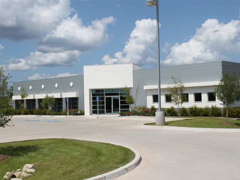 A large white building with a parking lot in front of it