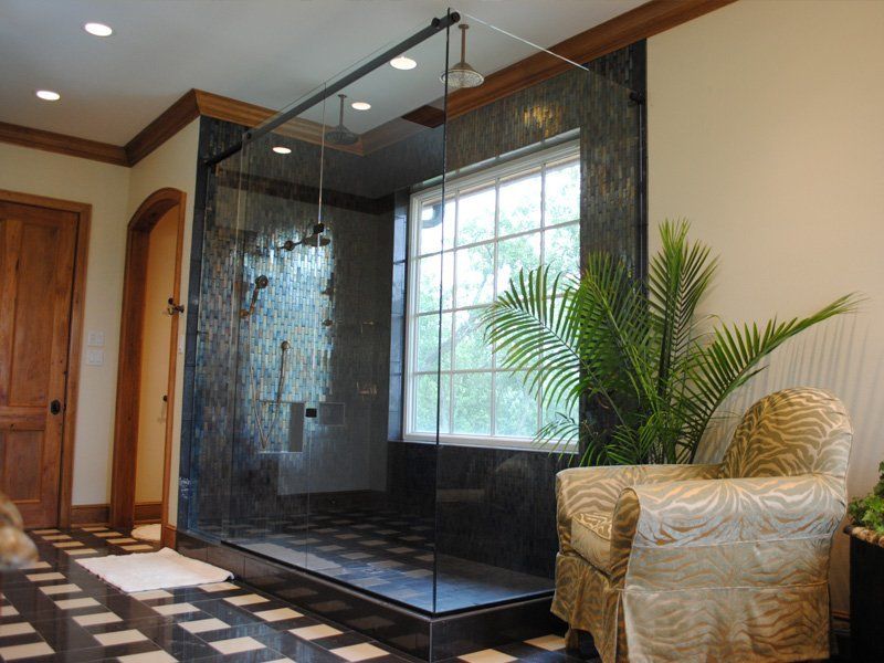 A bathroom with a walk in shower and a chair