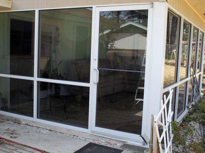 A white screened in porch with a lot of windows