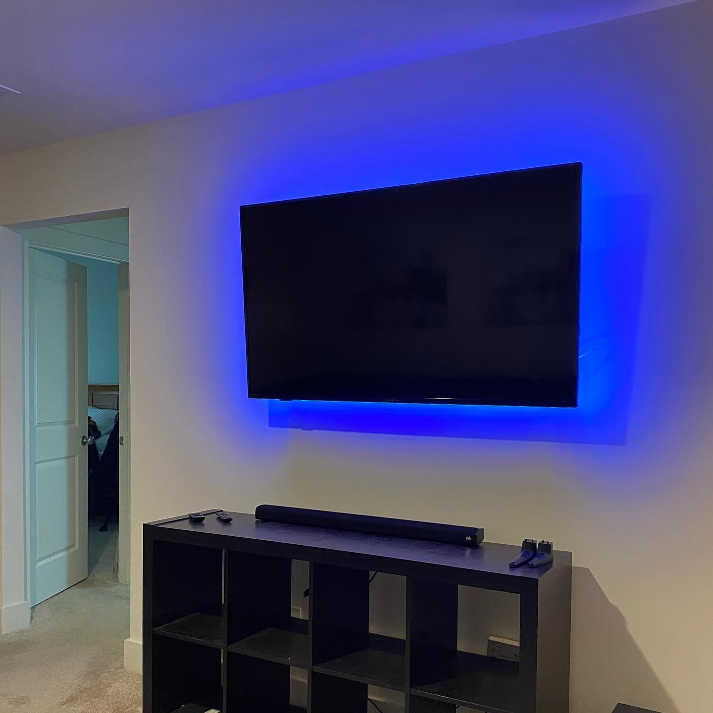 3Cs Audio-Visuals LLC | Wall-mounted TV installation with blue backlight and soundbar using professional tv mounting services