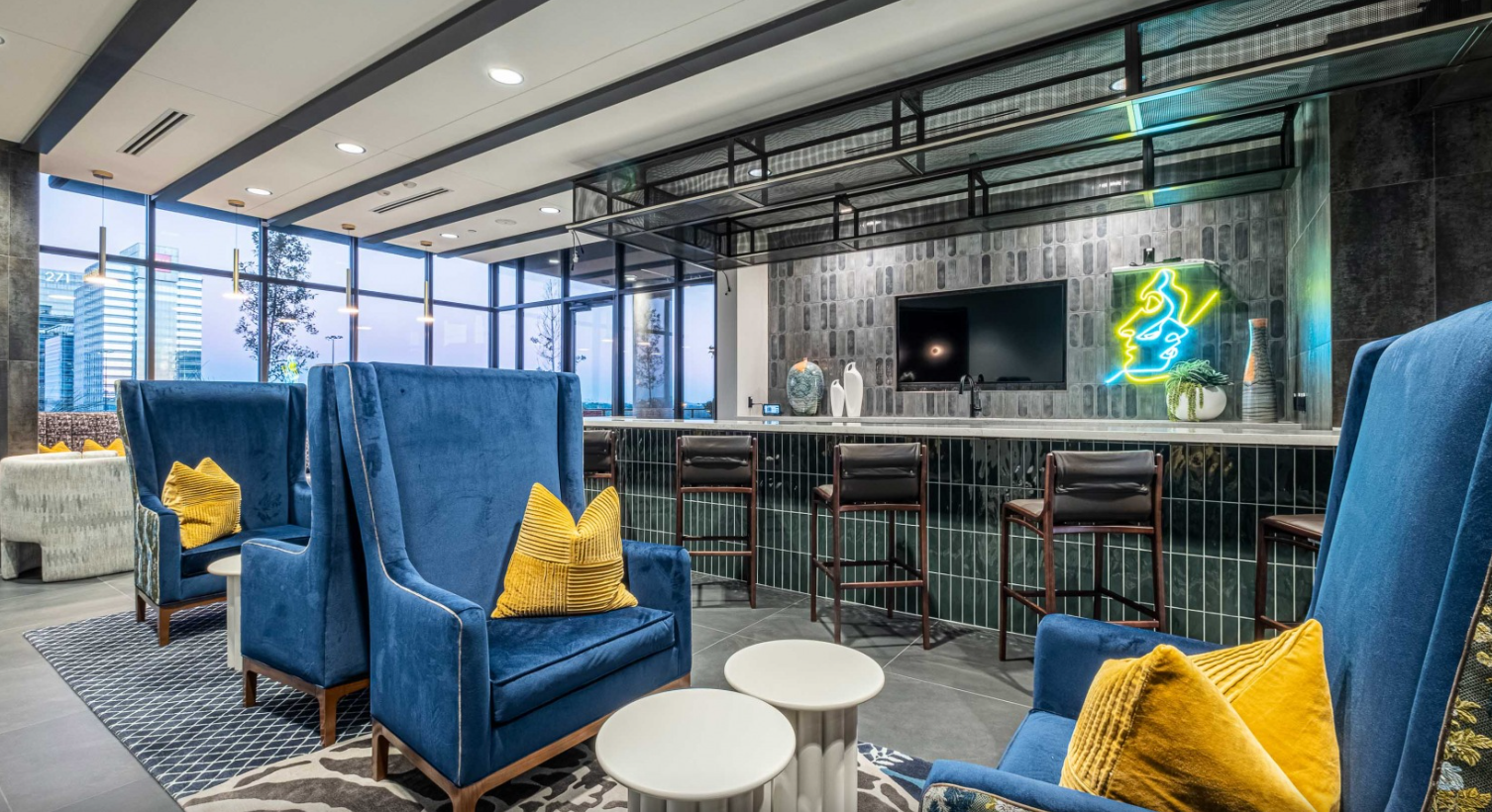 3Cs Audio-Visuals LLC | Commercial TV installations in modern lounge with neon art and bar seating area