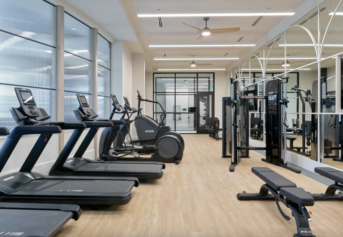 3Cs Audio-Visuals LLC | Commercial gym AV setup featuring mirrored wall and mounted screens for home theater system installation