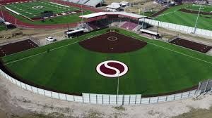 Baseball field with a large "S" logo, flanked by a football field and track.