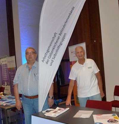 Messestand der AGB. Neben der weißen Beachflag mit dem Logo steht der Vorsitzende Dieter Harwardt. Eine weitere Person in namentlich nicht benannt.
