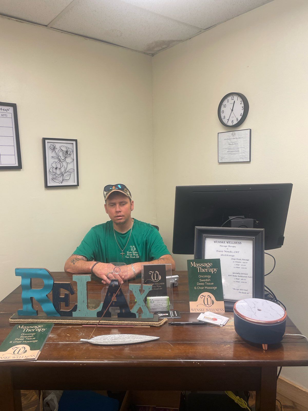 A person sits at a wooden desk with a 