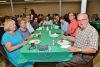A group of people are sitting at a long table eating food.