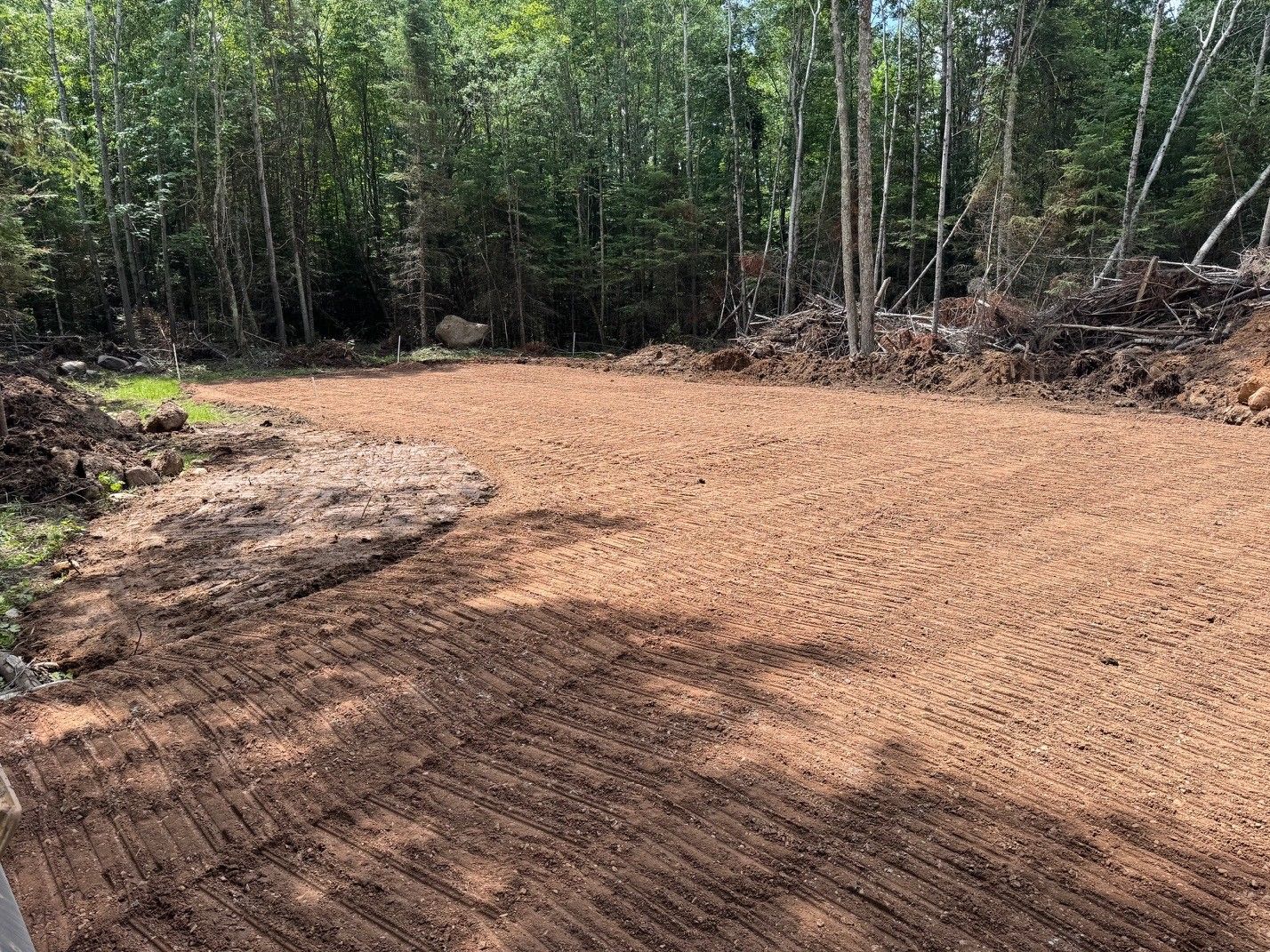 Dirt patch, possibly for construction, surrounded by trees.