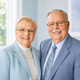 Smiling couple in light blue clothing posing indoors against a bright background