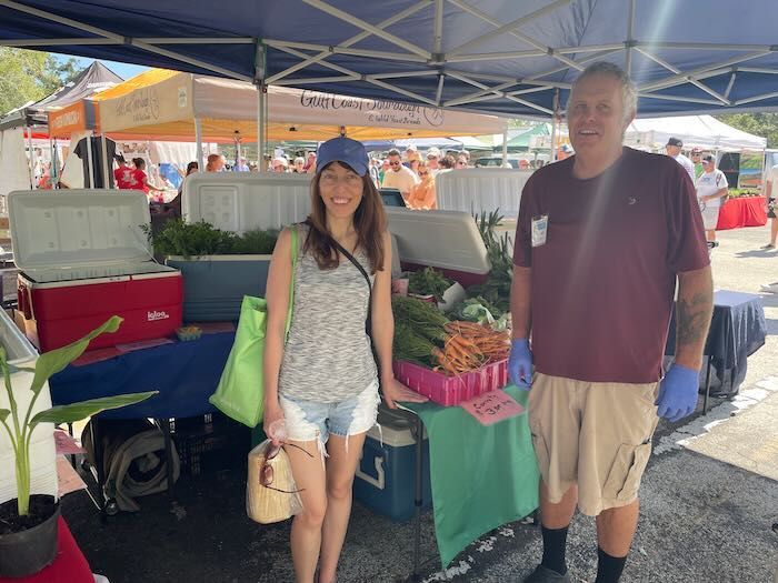 Peach Pit Farms Owner with a customer picking up their order at the farmers market
