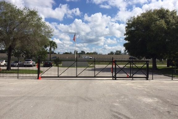There is a large gate in the middle of a parking lot.