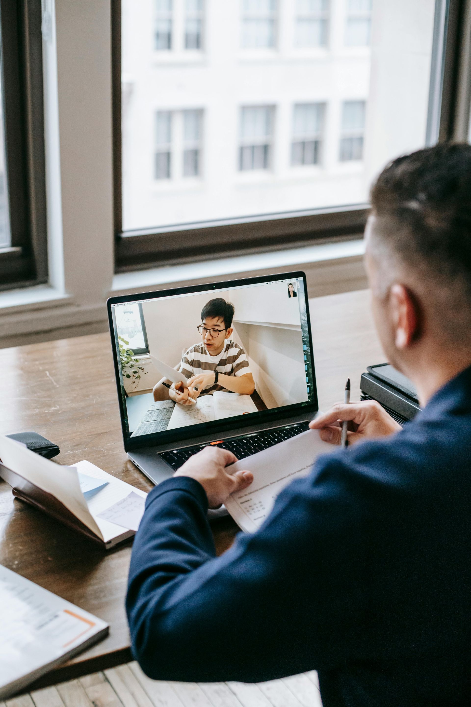 A man is sitting at a desk using a laptop computer.