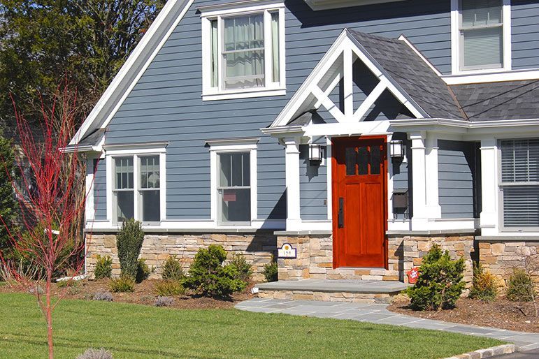 a blue house with a red door and white trim